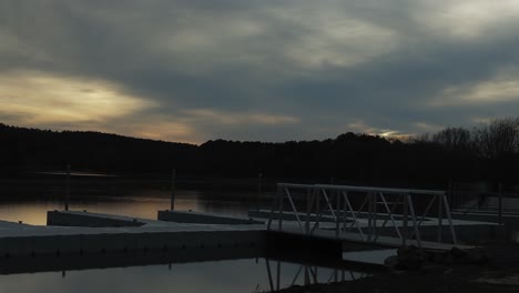 Lapso-De-Tiempo-De-Una-Puesta-De-Sol-Nublada-De-Invierno-Sobre-Un-Lago-Con-Muelles-En-Primer-Plano