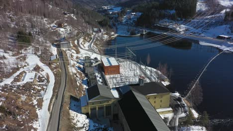 powerlines hanging above hydroelectric powerplant nore i and the rodberg dam - aerial showing stakraft powerplant with infrastructure in rodberg norway