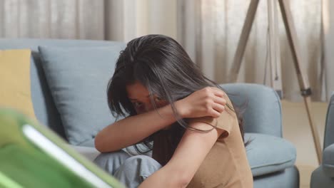 primer plano de una joven asiática víctima de violencia con moretones en el cuerpo sentada en el suelo asustada de un hombre con una botella de vidrio golpeándola en casa