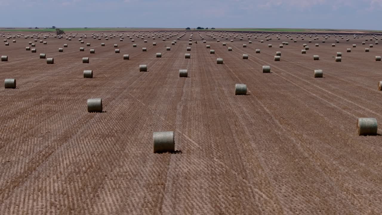 Drone aerial showing repeating hay bale patterns across open farmland