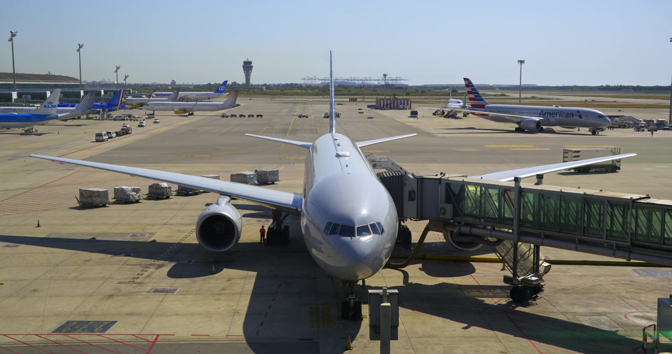 Aereo commerciale parcheggiato al gate dell'aeroporto con attività del personale di terra