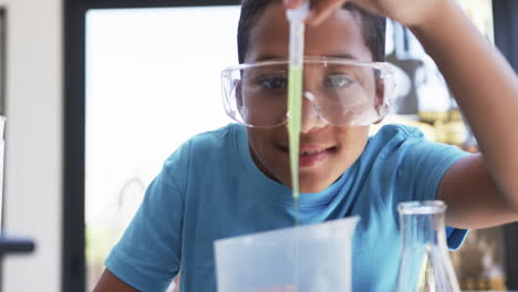 en un aula de laboratorio de ciencias de una escuela, un joven estudiante afroamericano lleva a cabo un experimento