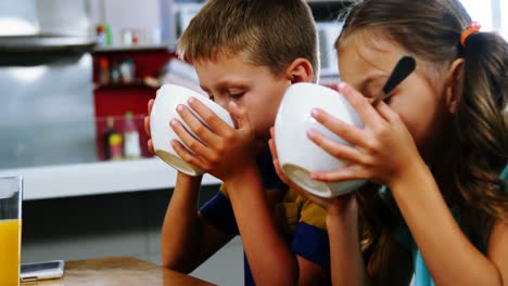 siblings having breakfast in kitchen