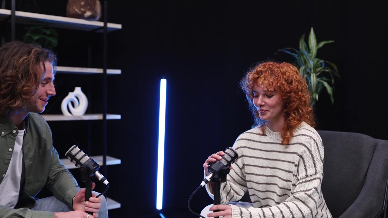 Ung mand og kvinde optager et podcastinterview i studie