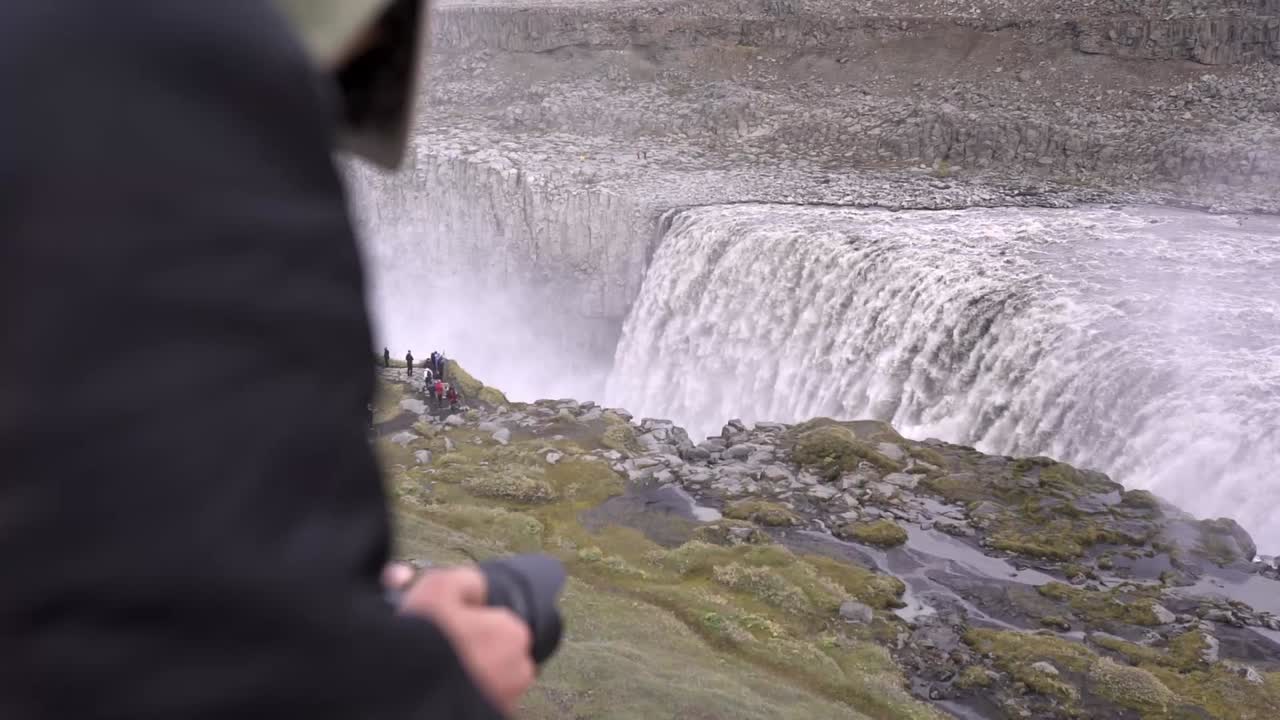 카메라에 폭포의 비디오를 촬영하는 여행자