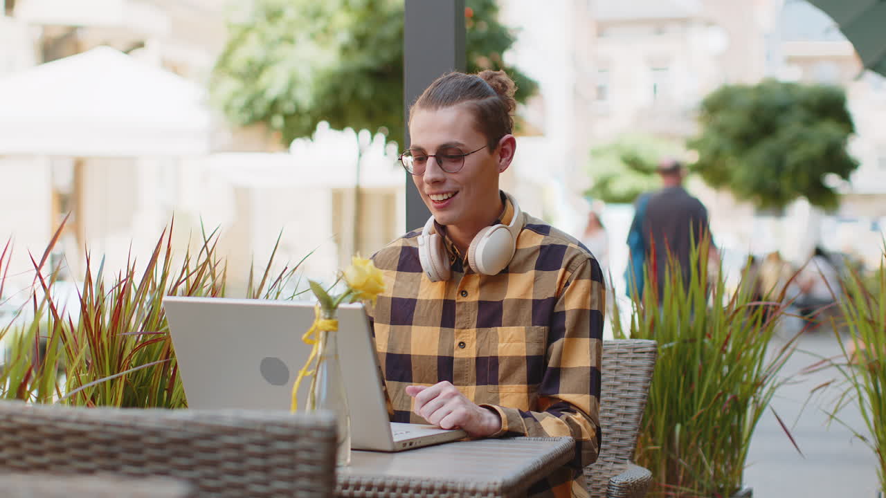 Tourist man use laptop having video call chat conversation online meeting presentation in city cafe