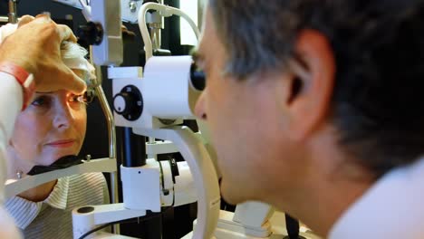 optometrista examinando los ojos del paciente con una lámpara de hendidura 4k