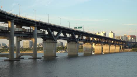 Subway-train-crossing-Cheongdam-Bridge-over-Han-river-In-Seoul,-South-Korea---static-wide-angle-shot