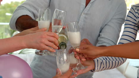 casual man pouring champagne in glasses