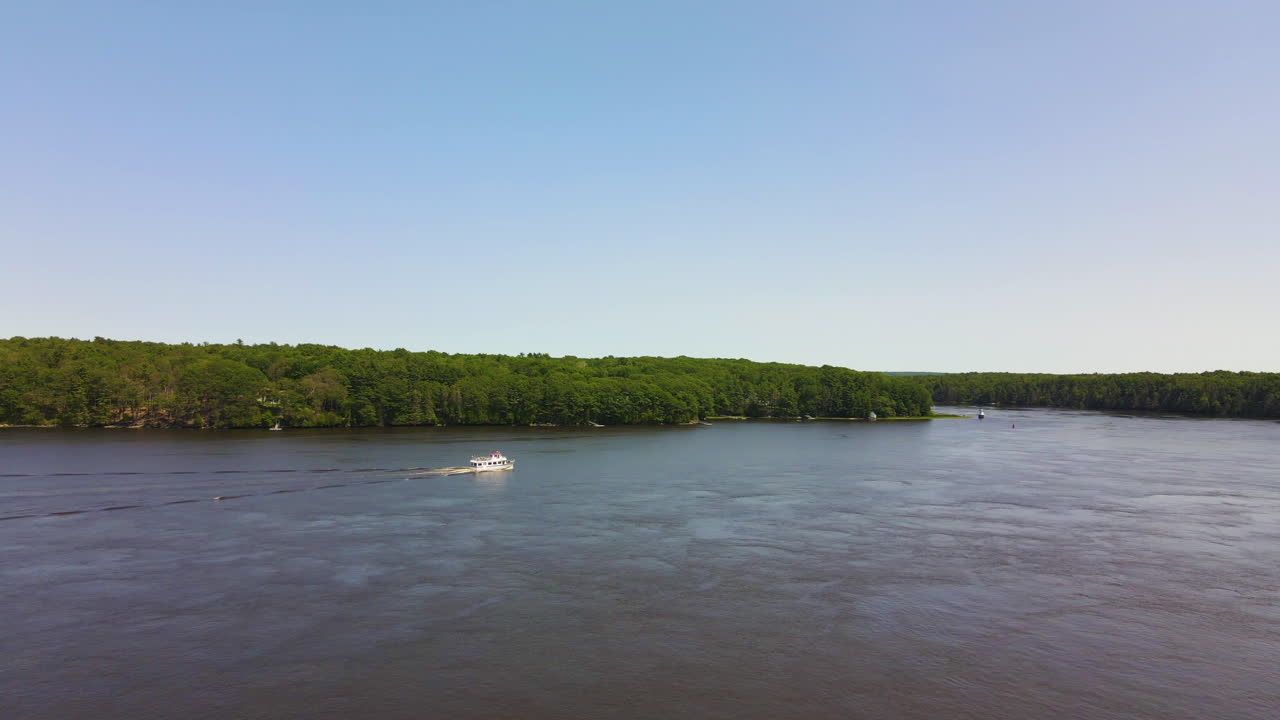 vuelo de un avión no tripulado sobre el río kennebec, mostrando un barco de placer en la distancia