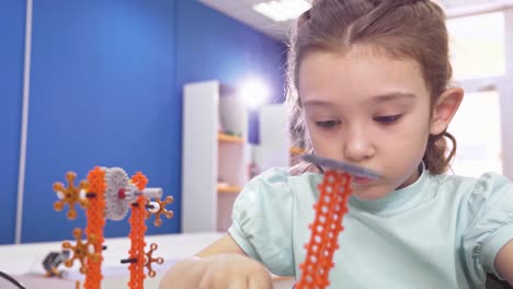 girl building a mechanical toy