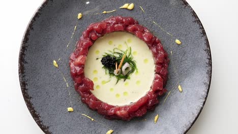 close-up un rotation of a plate of red tuna on a gray dish