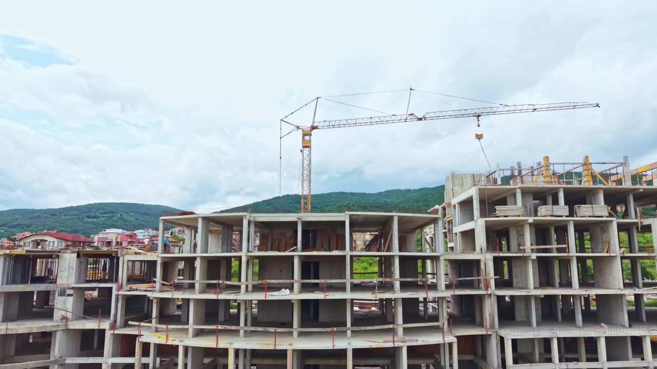 Avanzamento del cantiere. Cantiere urbano con macchinari attivi e operai. Costruzione in corso di una torre residenziale con impalcature e supervisione ingegneristica