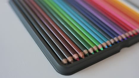 closeup of color pencils arranged in a rainbow pattern slowly rotating from angle