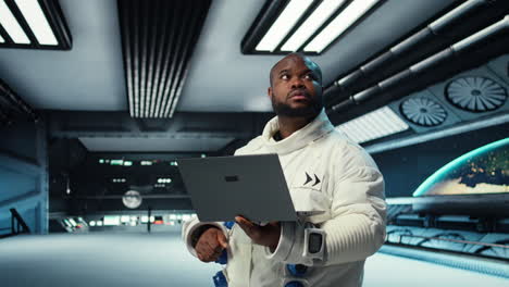 Vertical video Astronaut crew inside futuristic spacecraft monitoring mission data on laptop