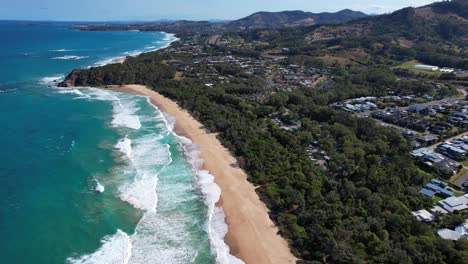 Playa-De-Zafiro-Con-Olas-Espumosas-Chapoteando-En-La-Orilla-Arenosa-En-Nueva-Gales-Del-Sur,-Australia---Toma-Aérea