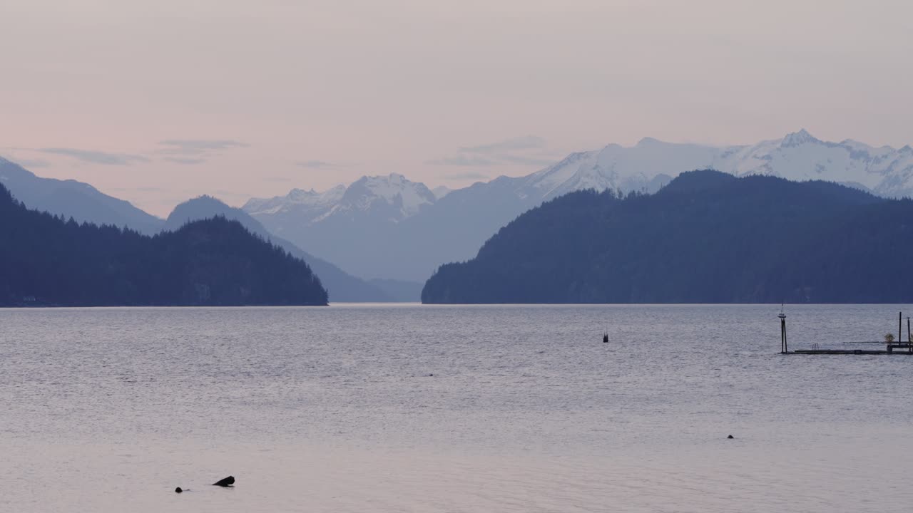 Il lago Harrison con le cime innevate delle montagne al tramonto nella Columbia Britannica, in Canada