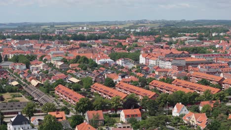 Skyline-of-Swedish-city-Ystad-on-a-sunny-summer-day,-aerial-telephoto-orbit