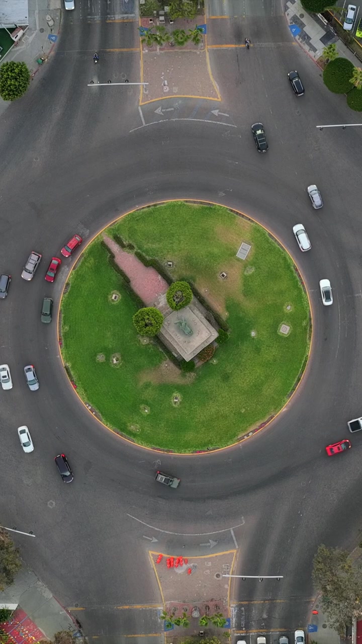 Close up top down aerial of traffic near the Monumento México roundabout on Paseo de los Héroes in Tijuana