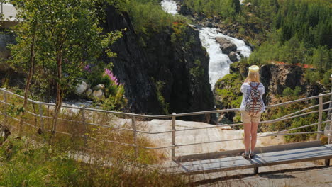 A-Woman-Looks-At-The-Majestic-Waterfall-Of-Woringsfossen-In-Norway-Impressive-Beauty-Of-Scandinavian