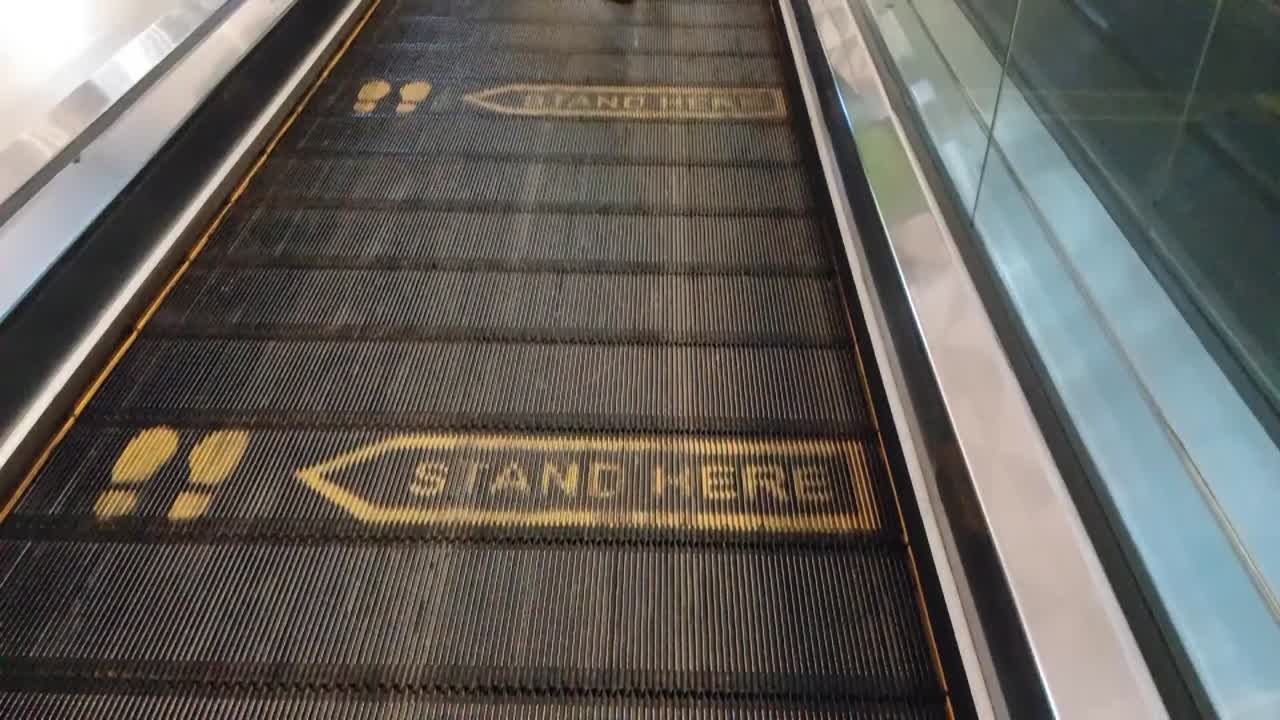 우주 푸라 회사의 일부인 수카르노-하타 공항의 에스컬레이터에서 승객들이 고 있습니다.