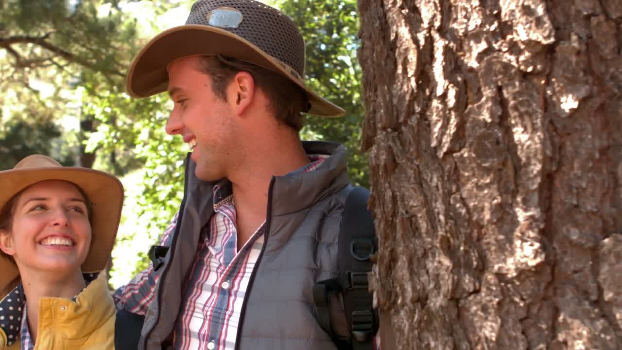 pareja sonriente en una caminata en el campo