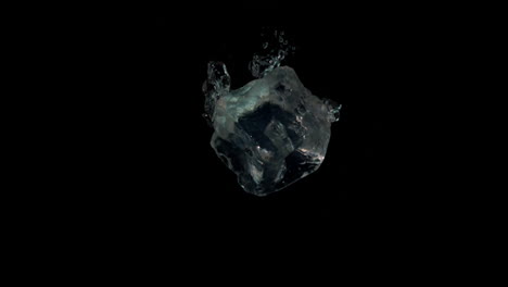 cubos de hielo cayendo en el agua sobre un fondo negro