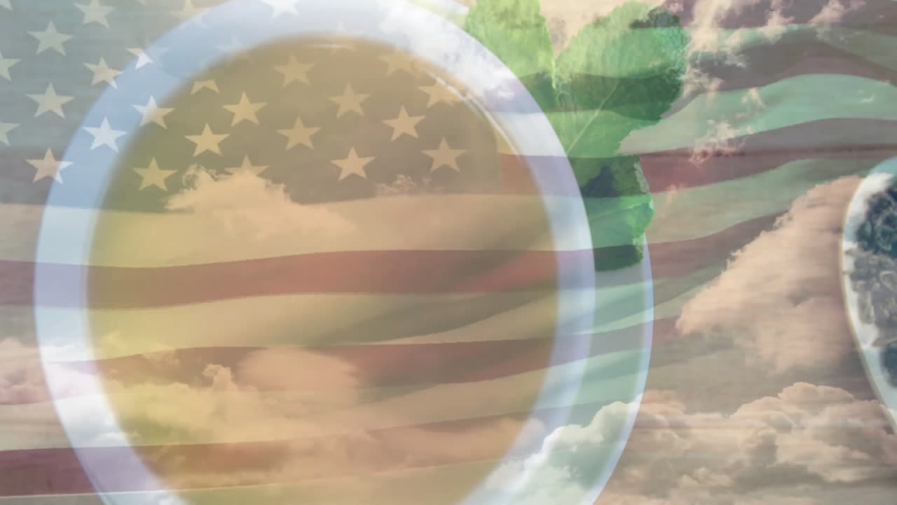White ceramic tea cup showcasing tea leaves and mint overlaying clouds and flag stripes in flat-lay