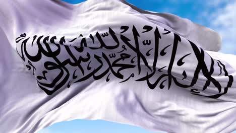 the flag of the islamic emirate of afghanistan waving in the wind.