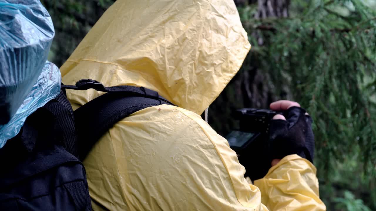 excursionista tomando fotos bajo la lluvia