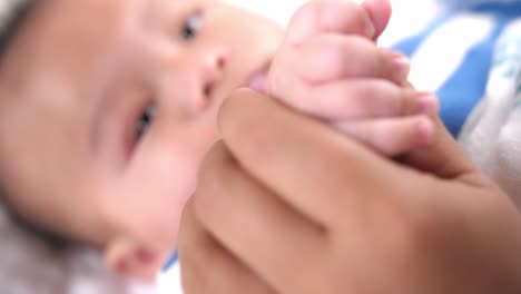cute baby holding mother's finger, video in 4k