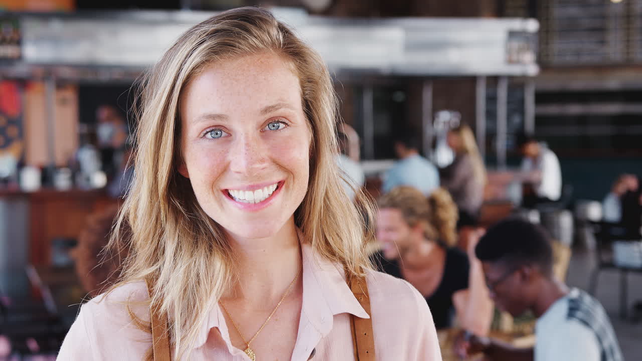 바쁜 술집 레스토랑에서 카메라를 향해 미소 짓는 웨이트리스의 초상화