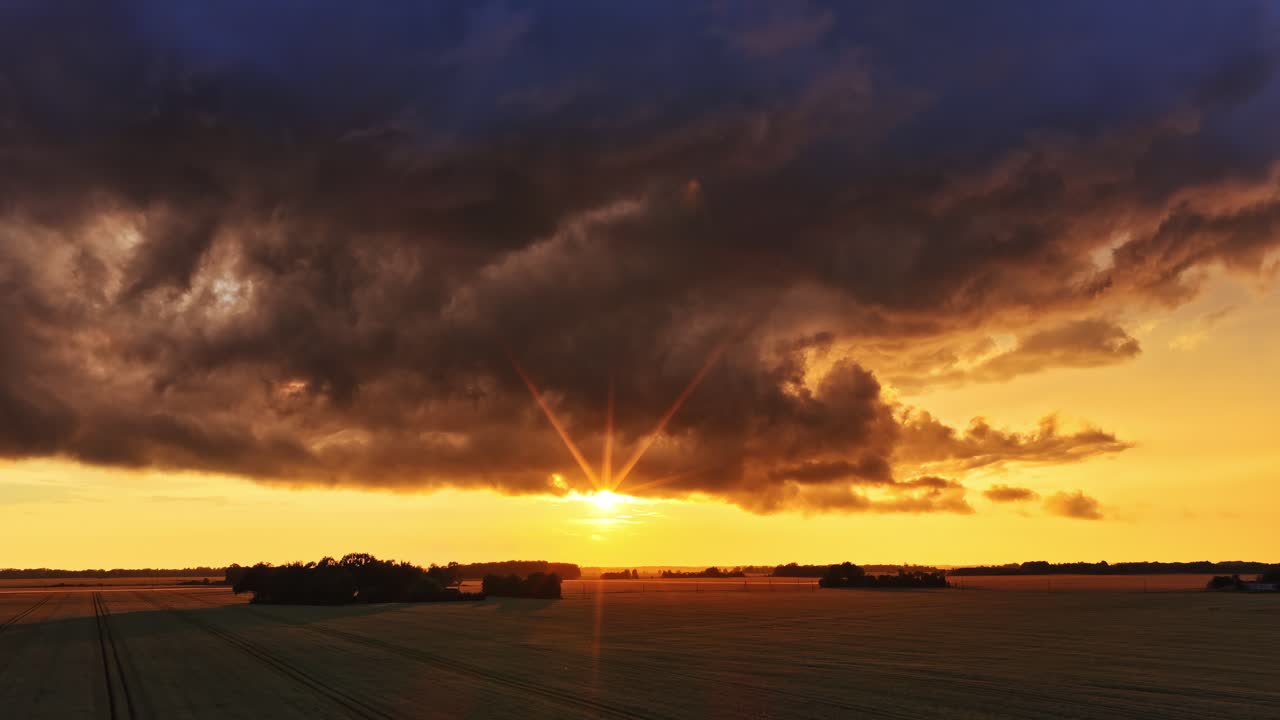 Sonne, die unter einem Horizont untergeht und warmes Licht über leeres Gelände wirft, Luftaufnahme.