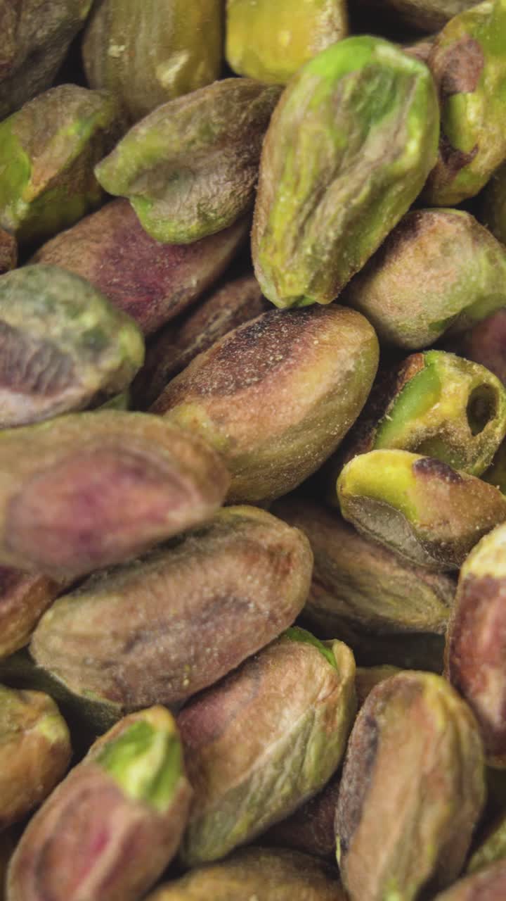 Detailed macro shot of raw pistachio nuts with vibrant green and beige tones, highlighting natural textures and freshness. Perfect for food backgrounds or ingredient visuals