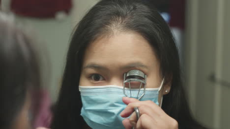 girl with face mask, curling eyelashes in front of mirror, slow motion