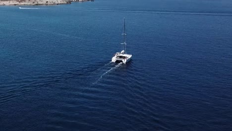 aerial drone shot yacht blue water mykonos