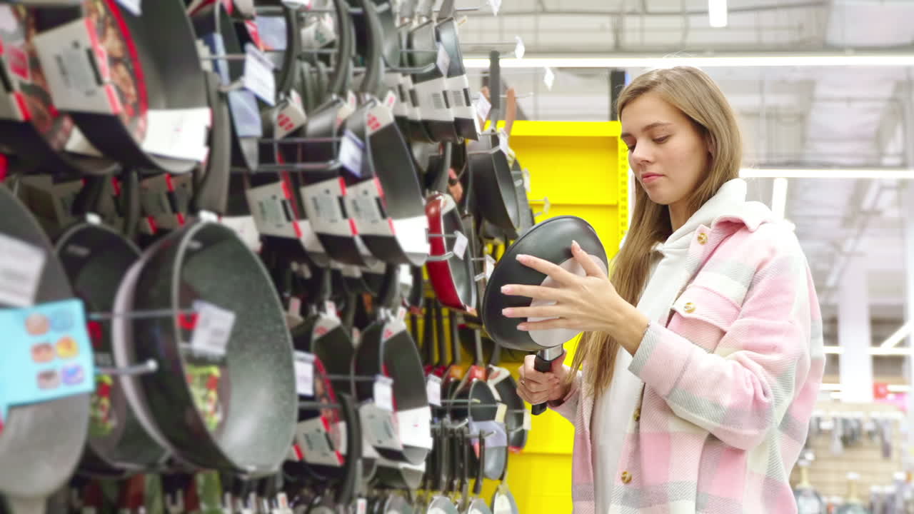 Mulher comprando panelas em um supermercado