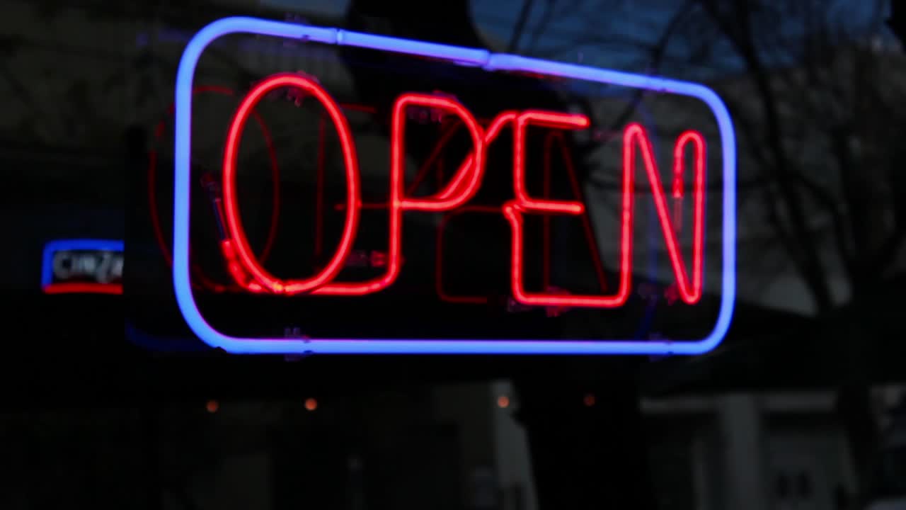 Red and Blue Neon Open Sign Glowing in a Dark Window