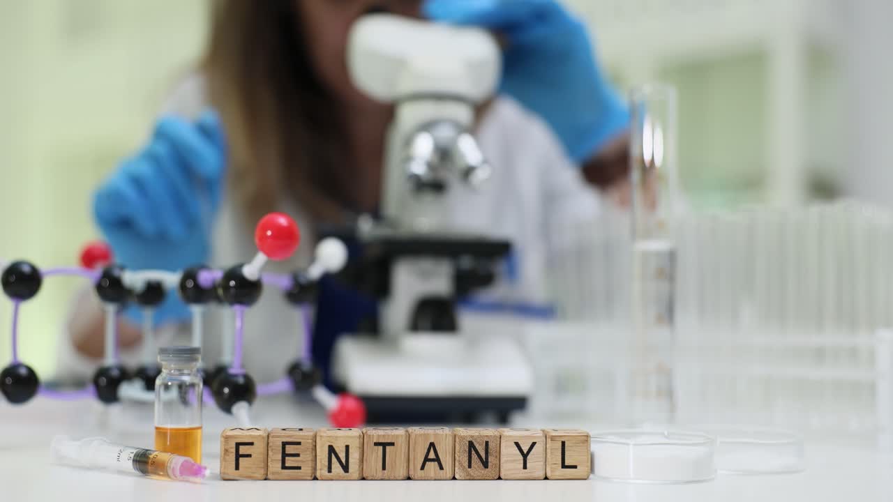 Tecnico di laboratorio esamina una sostanza attraverso un microscopio ad alta potenza