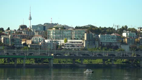 The-Hangang-River-and-Namsan-Tower-in-Seoul,-South-Korea-with-traffic-motion-and-north-city-skyline