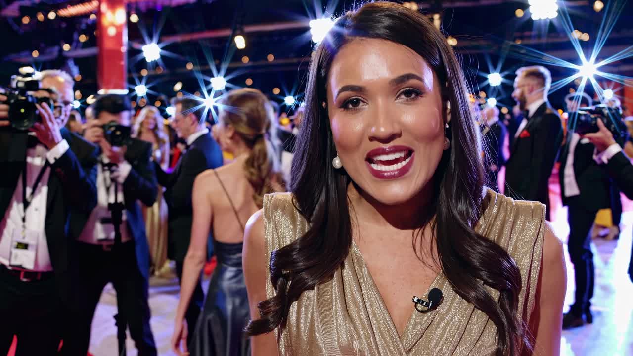 Glamorous red carpet event video, captured from a low-angle, showcasing a woman in a gold dress