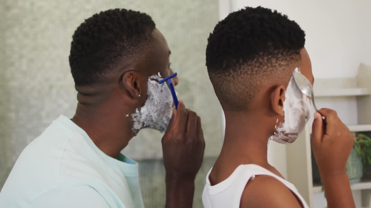 Padre e figlio afroamericani che si radono insieme
