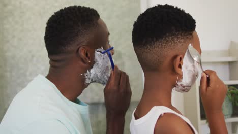 African-american-father-and-son-shaving-together