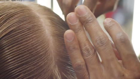 Afroamerikanischer-Friseur,-Der-Das-Nasse-Haar-Des-Kunden-In-Teile-Teilt