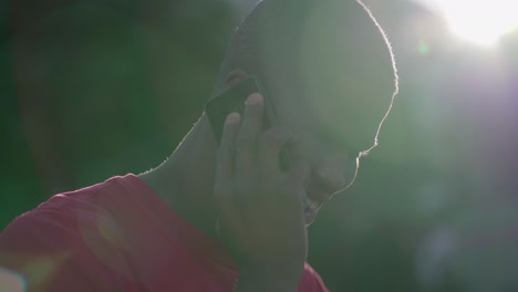 Primer-Plano-De-Un-Hombre-Afroamericano-Hablando-Por-Teléfono-En-El-Parque,-Sonriendo