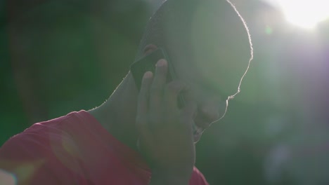 primer plano de un hombre afroamericano hablando por teléfono en el parque, sonriendo