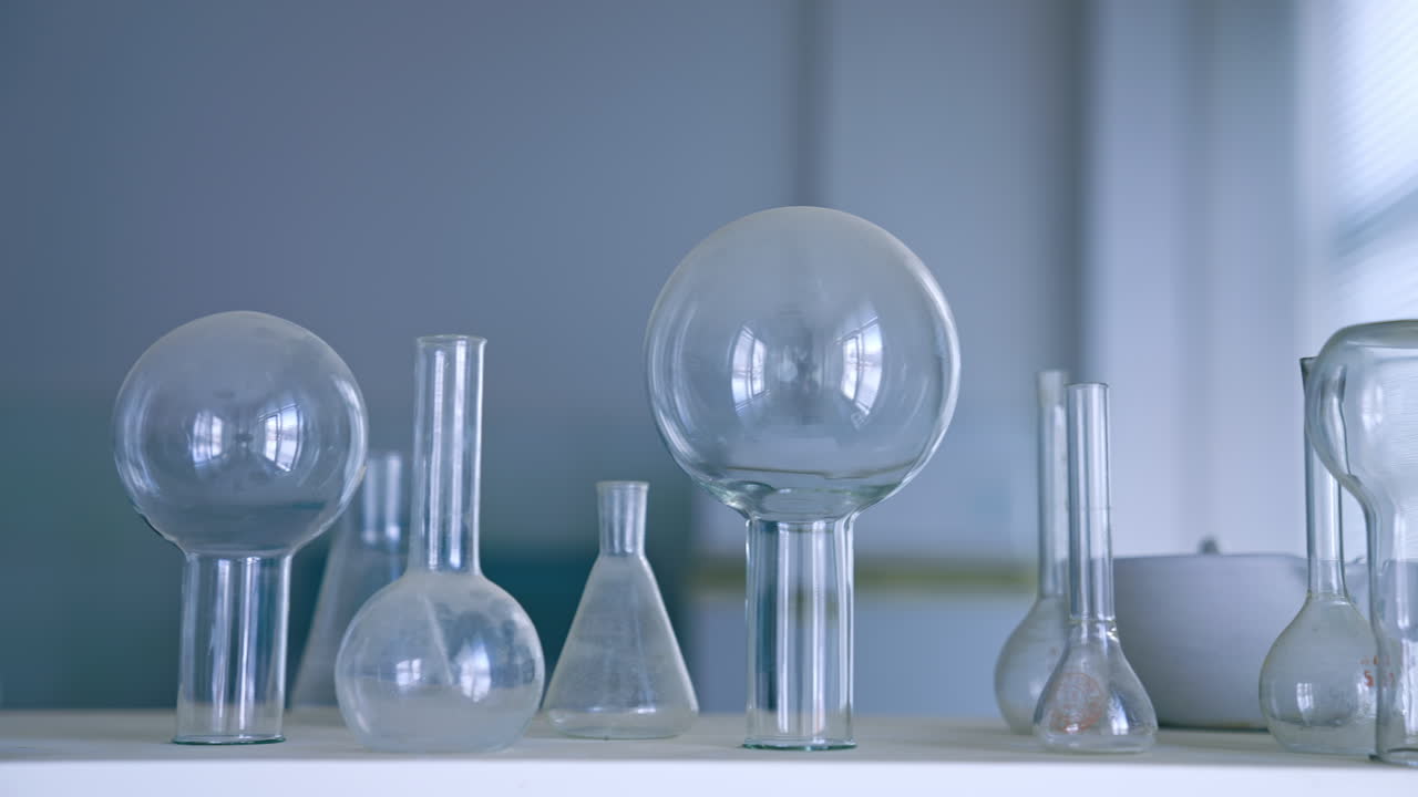 Glass flasks and beakers on the table. Medical laboratory appliances. Close up.