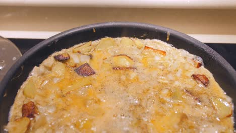 deliciosa tortilla española con patata y cebolla frita en una sartén