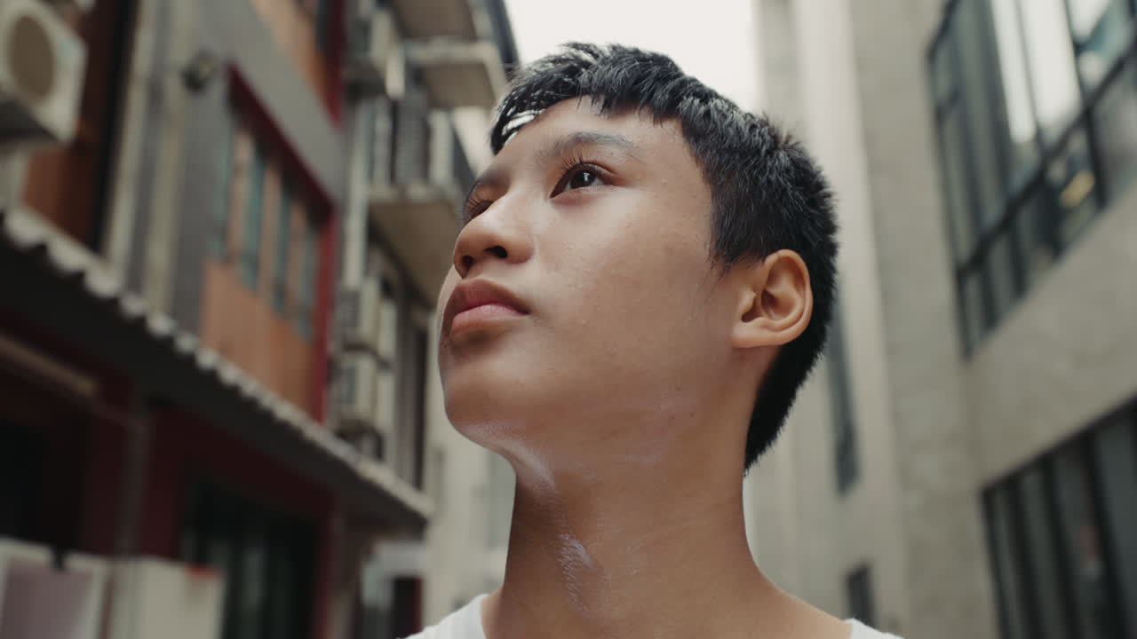 Teenage boy looking up in alleyway