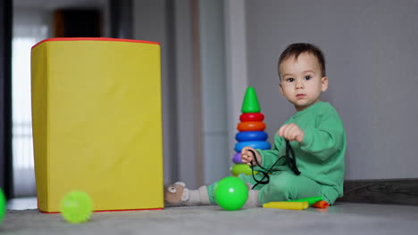 toddler playing with stacking rings and toys